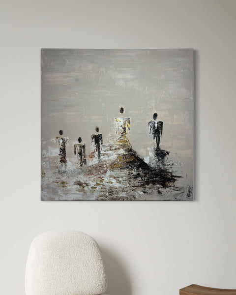 Interior view featuring SOUL I by Marjolein Marx, a square canvas with six abstract figures emerging from layered earth tones and textured white highlights, mounted on a neutral wall above a modern chair.